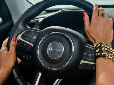 Imagem de mãos femininas a segurarem volante
